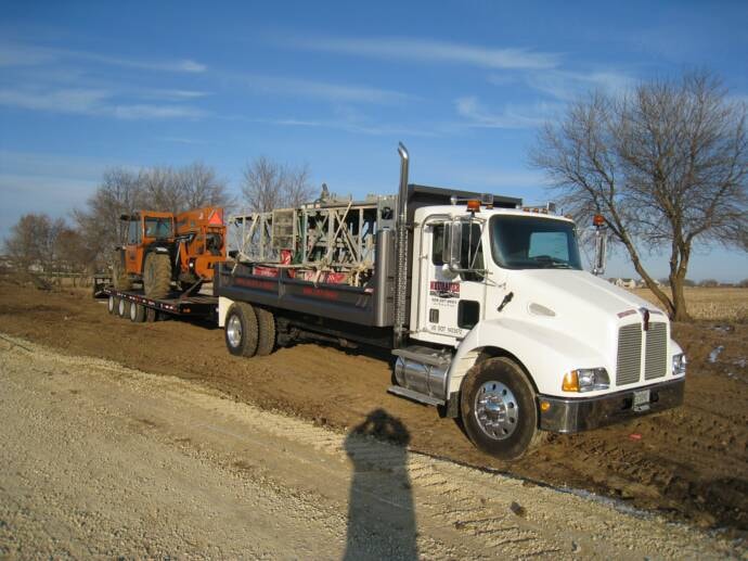 Neubauer Masonry truck hauling scaffolding and telehandler